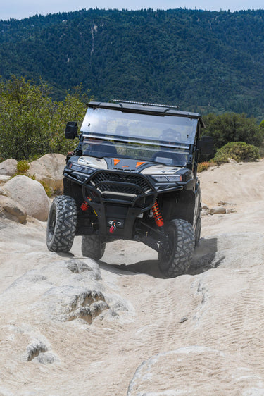 Dengao PowerSports RanchHawk 650FI riding an offroad trail and going over boulders.